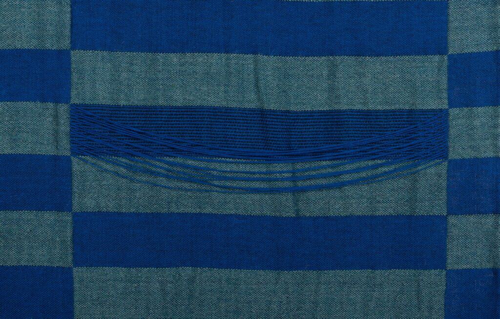 Interwoven dark and light blue threads make an elongated grid pattern.