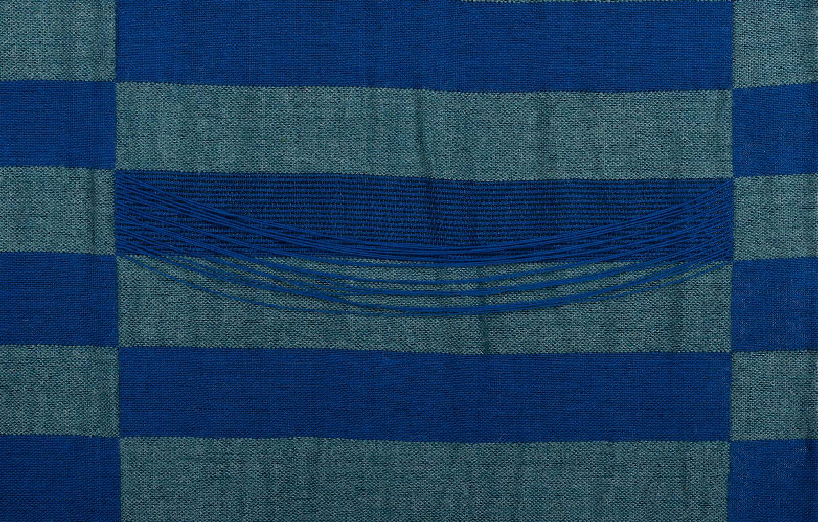 Interwoven dark and light blue threads make an elongated grid pattern.